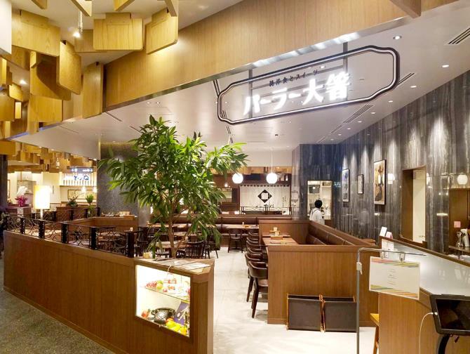 パーラー大箸の看板と、木のテーブルやソファ席が並ぶ店内